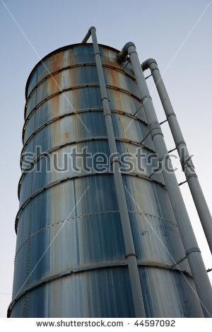 stock-photo-rusty-industrial-blue-metal-tank-against-clear-sky-44597092
