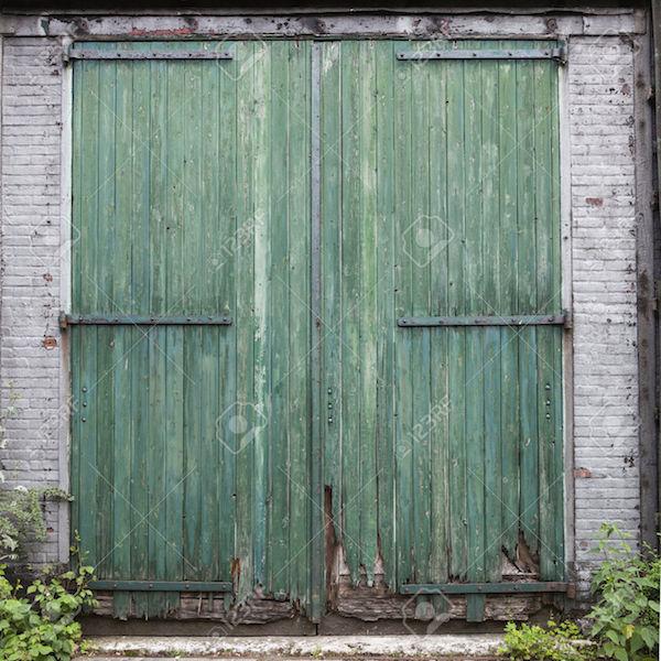 41930307-large-old-barn-doors-with-peeling-green-paint-in-white-brick-wall-Stock-Photo